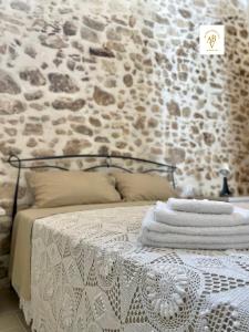 维科德尔加尔加诺Arcaroli Borgo Vico "Exclusive"的一张带毛巾的石墙床