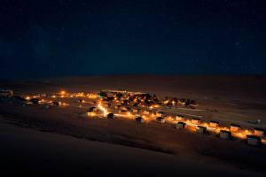 ShāhiqThousand Nights Camp的一群夜晚在沙漠中的灯光