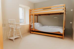 TréhorenteucAuberge Val sans retour的卧室配有双层床、椅子和凳子。