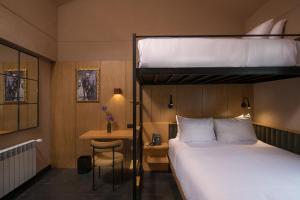 库斯科Motto By Hilton Cusco的配有双层床和书桌的酒店客房