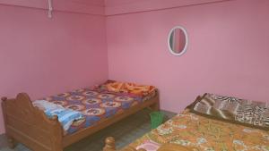 Jyoti GaonMANAS RAY HOMESTAY的一间卧室设有两张床,墙上设有一面镜子