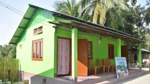 Jyoti GaonMANAS RAY HOMESTAY的前面有标志的绿色多彩房子
