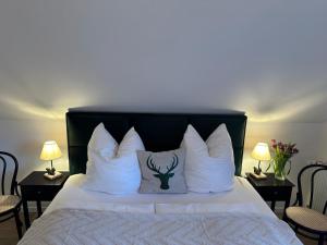 费尔德伯格BergOase-Apart am Feldberg的床上配有白色枕头和鹿枕