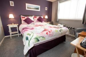 奈恩Fonthill Bed and Breakfast Nairn的一间卧室配有一张带花卉床罩的大床
