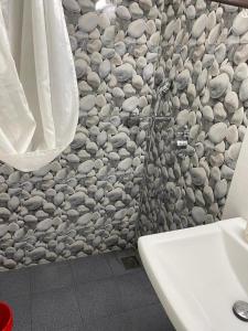 巴加Tony's Inn Baga Apartment的浴室设有石墙和水槽