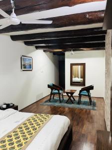 斯利那加Main Street Inn的一间卧室配有两把椅子、一张床和镜子