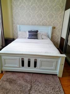 内罗毕the perfect affordable apartments的卧室内的一张白色床,铺着地毯