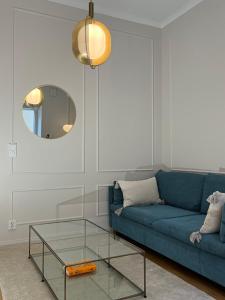 赫尔辛基Central, peaceful, high-end apartment的客厅配有蓝色的沙发和玻璃桌