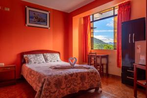 圣拉蒙Refugio Hotel的一间卧室拥有橙色的墙壁、一张床和窗户