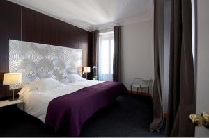 马德里普拉多套房酒店的一间卧室配有一张大床和紫色毯子