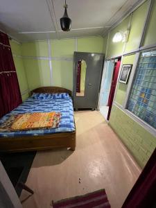 古瓦哈提Hemalata Heritage Home的卧室位于客房的角落,配有一张床