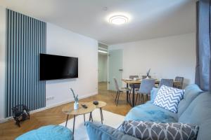 德累斯顿CoView - ruhige Design Wohnung - 2 Schlafzimmer - voll ausgestattete Küche的客厅配有蓝色的沙发和电视