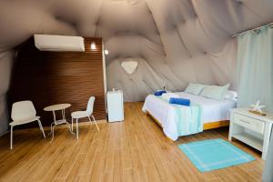 蓬塔露奇亚Hotel Don Bululo Camping Lodge的卧室配有一张床和一张桌子及椅子