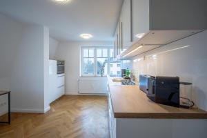 德累斯顿CoView - ruhige Design Wohnung - 2 Schlafzimmer - voll ausgestattete Küche的厨房设有白色的墙壁和台面