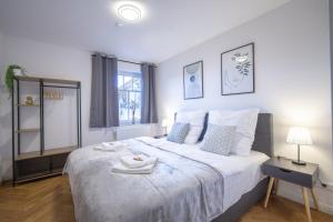 德累斯顿CoView - ruhige Design Wohnung - 2 Schlafzimmer - voll ausgestattete Küche的卧室设有一张白色大床和一扇窗户。