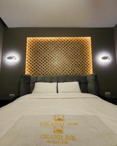 KukësGRAND JNK Boutique Hotel的一间卧室配有一张带大床头板的床