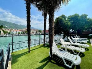 帕拉蒂科Hotel Stazione sul lago di Iseo的水边的一排白色躺椅