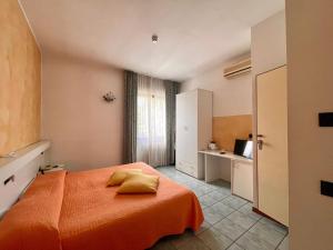 帕拉蒂科Hotel Stazione sul lago di Iseo的一间卧室配有一张带橙色毯子的床