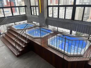 巴拉奈里奥-坎布里乌达斯阿莫瑞卡斯酒店的一座建筑顶部的笼子,上面有一个游泳池