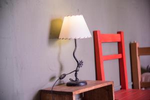 乌玛瓦卡Hostel La Humahuacasa的红椅旁边的桌子上的灯