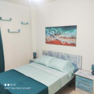 坎德拉里亚APARTAMENTO NAIR的卧室配有一张床,墙上挂有绘画作品