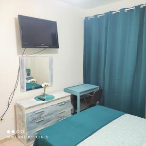 坎德拉里亚APARTAMENTO NAIR的一间卧室配有一张床、镜子和电视