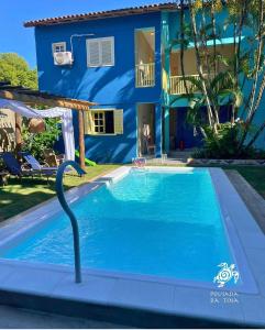 安谢塔Pousada da Tina的蓝色房子前的游泳池