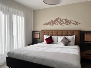 坎皮泰洛迪法萨Hotel Rododendro Val di Fassa的卧室配有一张大床,墙上挂着群山