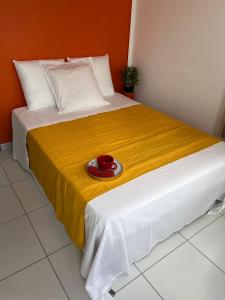 法兰西堡Republique Lounge的一张黄色毯子和红色碗的床