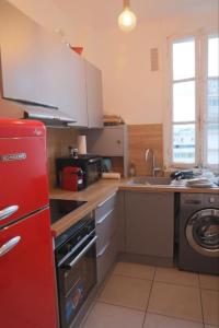库尔布瓦Profitez du calme de Courbevoie La Défense的厨房配有红色冰箱和水槽