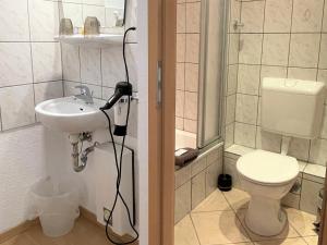 波鸿Hotel Antoni的带淋浴、盥洗盆和卫生间的浴室
