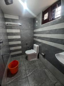 瓦尔卡拉New PALM BAY RESIDENCY的一间带卫生间、水槽和水桶的浴室