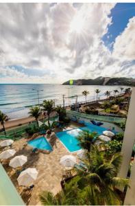 纳塔尔Beira-Mar flat 310 Ponta Negra Beach的享有带两个游泳池和大海的度假胜地的景致
