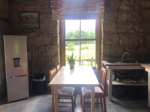 菲克斯堡Franshoek Farm的厨房配有桌子、冰箱和窗户。