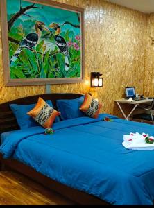 高兰Easy Life Country House的卧室配有一张蓝色的床,墙上挂着一幅画