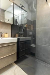 温科夫齐Apartman NEBO的一间带水槽和玻璃淋浴的浴室