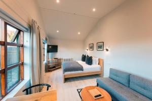 弗吕济Garður Stay Inn & Secret Lagoon的一间卧室配有一张床、一张沙发和一张桌子