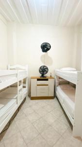 萨尔瓦多Hostel Canto Zen的客房设有白色双层床和天花板。