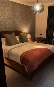 PenshurstThe Leicester Arms Country Inn的一间卧室配有一张大床和一盏灯