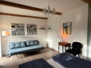 维比Lindegaardens Bed and Breakfast的客厅配有蓝色的沙发和桌子