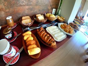 伊塔卡雷Pousada Natureza Viva的一张桌子,上面摆放着各种面包和糕点