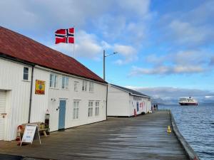 勒丁恩1. etg i Dampskipsbrygga, Lødingen havn的码头上的一座建筑物,上面有旗帜