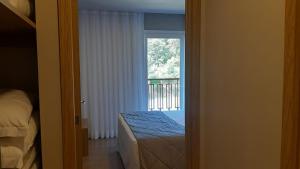 格拉玛多Golden Laghetto Gamado的一间卧室设有一张床和一个阳台的窗户。