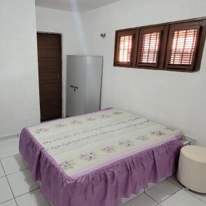 蒂鲍Casa em Tibau RN的一张位于带紫色床罩的房间内的床铺