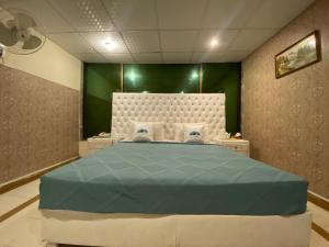 伊斯兰堡Fusion Lodge的一间卧室设有一张大床和绿色的墙壁