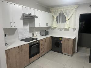 SandtonFourways Oasis的厨房配有白色橱柜、洗衣机和烘干机