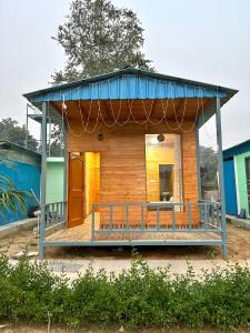 古尔冈Farm with 5 huts, heated pool and bonfire的蓝色屋顶的小房子