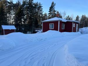 JärboLillhuset的一条雪覆盖的道路,通往红色的建筑