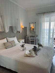 库卡里阿芙拉起亚酒店的卧室配有一张白色大床,上面有两本书