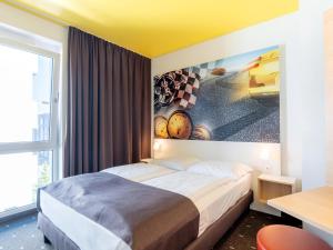 斯图加特B&B Hotel Stuttgart-Zuffenhausen的一间卧室配有一张壁画床